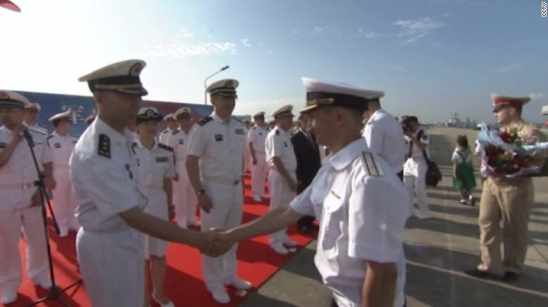 Russian and Chinese officers greet each other at the beginning of eight days of military exercises.